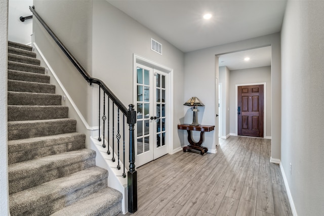 foyer entrance featuring french doors and hardwood / wood-style flooring