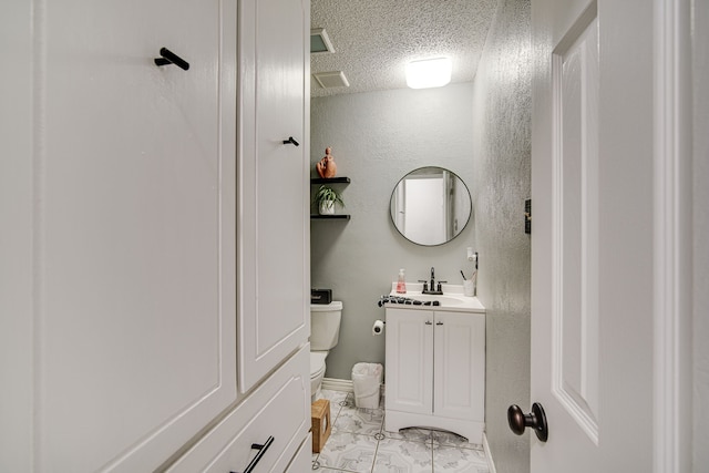 bathroom with a textured ceiling, toilet, tile patterned floors, and vanity