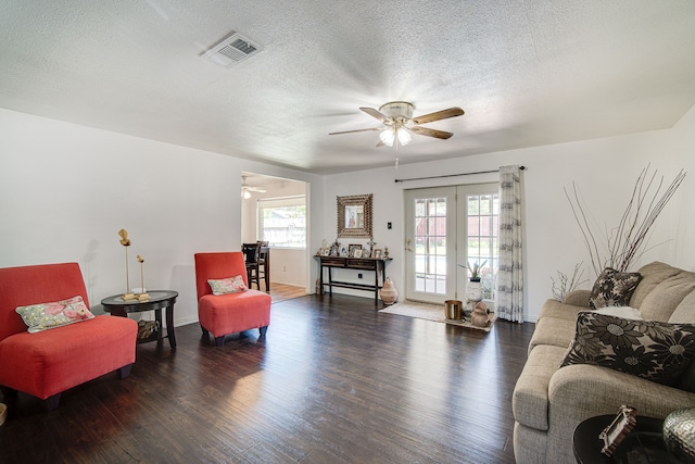 living room with ceiling fan, wood-type flooring, french doors, and a textured ceiling