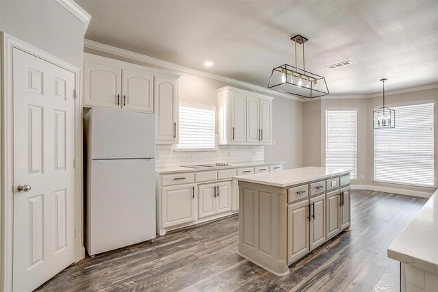 kitchen featuring white fridge, dark hardwood / wood-style floors, backsplash, a center island, and white cabinets