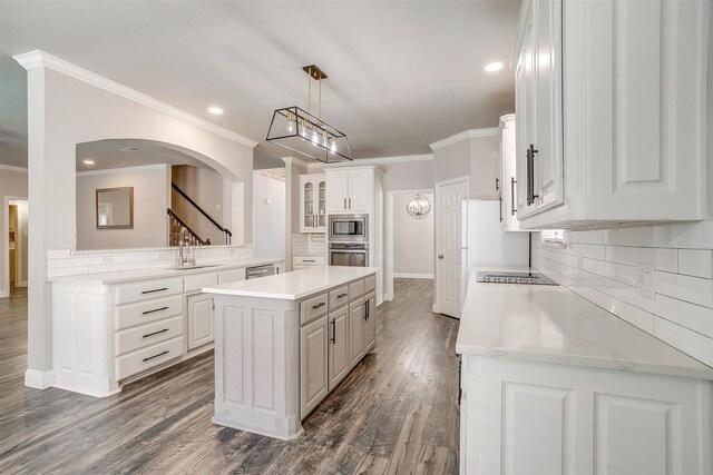 kitchen featuring white cabinetry, tasteful backsplash, dark hardwood / wood-style flooring, a kitchen island, and appliances with stainless steel finishes