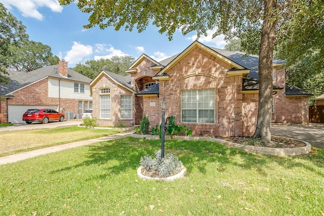 traditional-style home with driveway, a shingled roof, a front lawn, and brick siding