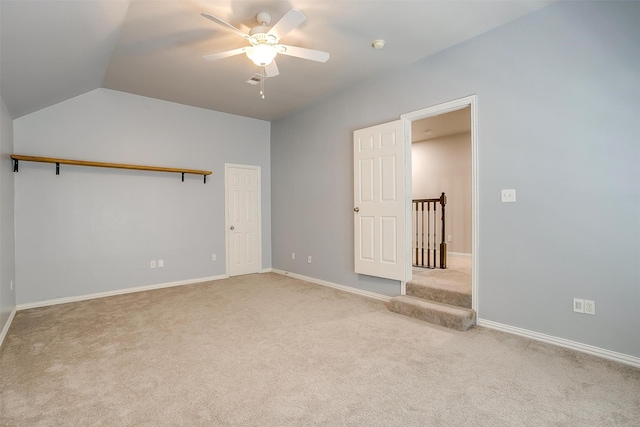 carpeted empty room featuring vaulted ceiling and ceiling fan