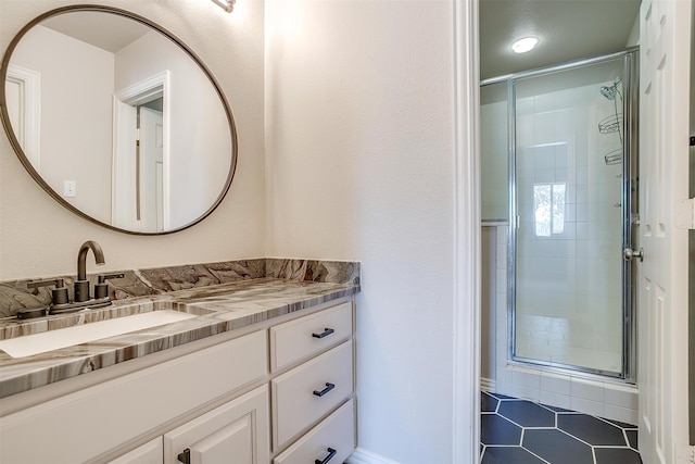 bathroom featuring tile patterned flooring, a shower with door, and vanity