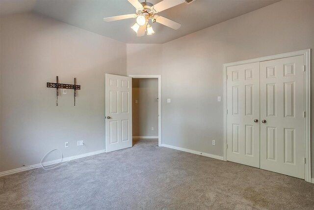 unfurnished bedroom featuring light colored carpet, high vaulted ceiling, ceiling fan, and a closet