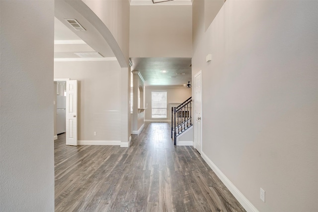 hallway with a high ceiling and dark hardwood / wood-style flooring