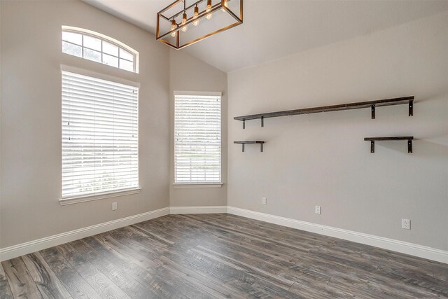 unfurnished room featuring lofted ceiling, a healthy amount of sunlight, and dark hardwood / wood-style floors