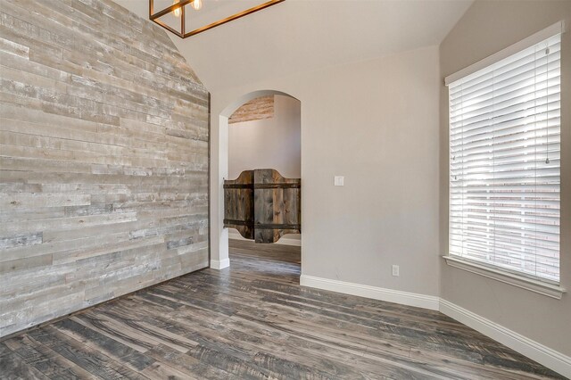 spare room with lofted ceiling and dark hardwood / wood-style floors