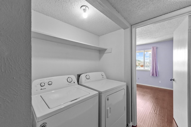 laundry room featuring washing machine and dryer, hardwood / wood-style flooring, and a textured ceiling