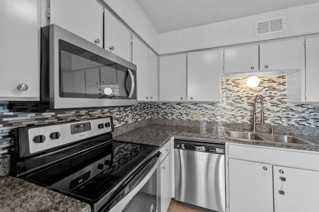 kitchen with a textured ceiling, white cabinetry, appliances with stainless steel finishes, tasteful backsplash, and sink