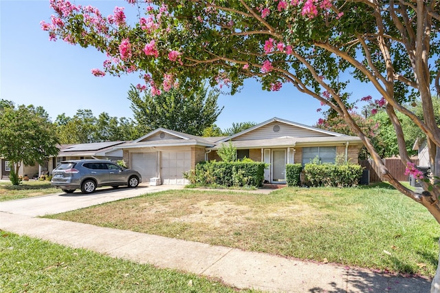 single story home featuring a garage, a front yard, and solar panels