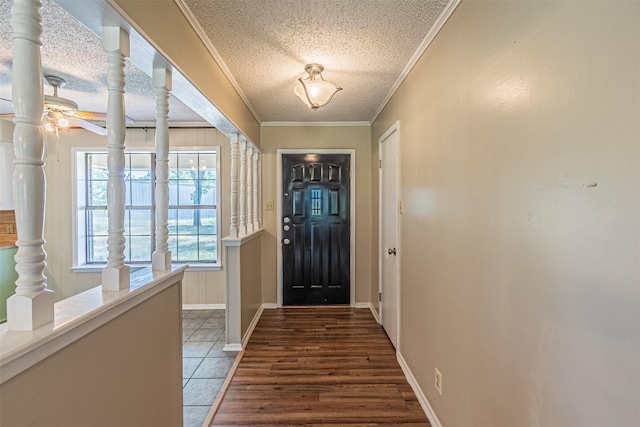 entrance foyer with ceiling fan, ornamental molding, a textured ceiling, and dark tile patterned floors