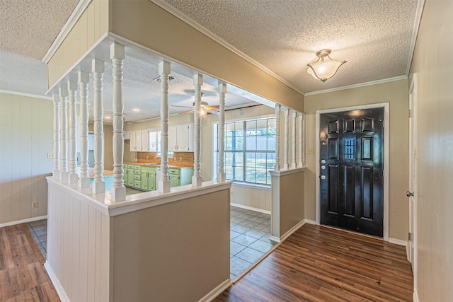 foyer with ceiling fan, wood-type flooring, ornamental molding, and a textured ceiling