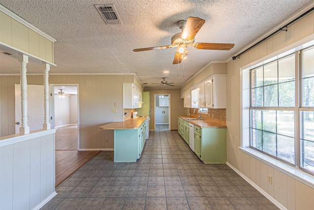 kitchen with wood counters, plenty of natural light, green cabinets, and sink