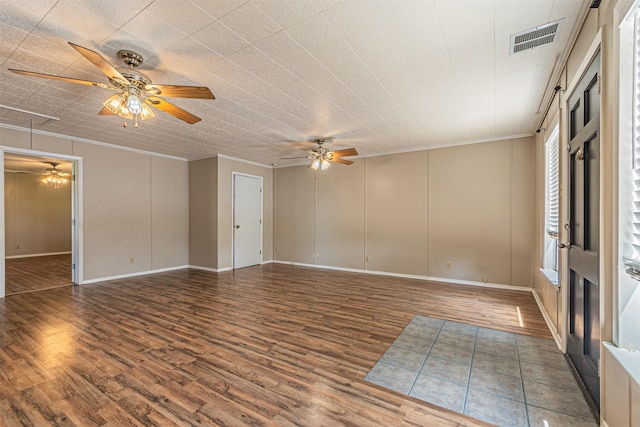 empty room with crown molding, dark wood-type flooring, and ceiling fan