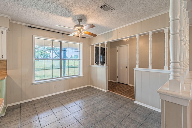 tiled spare room with crown molding, a textured ceiling, and ceiling fan