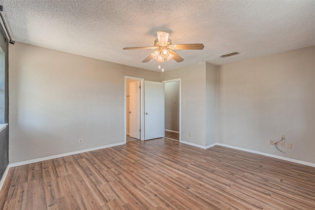 spare room featuring a textured ceiling, light hardwood / wood-style floors, and ceiling fan