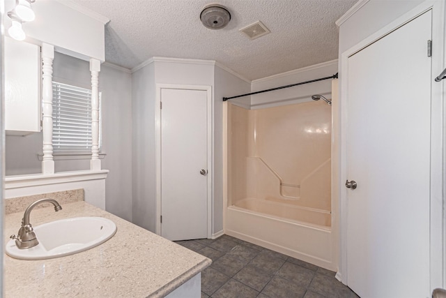 bathroom featuring ornamental molding, a textured ceiling, washtub / shower combination, and vanity