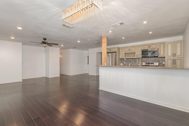 unfurnished living room featuring dark wood-type flooring and ceiling fan