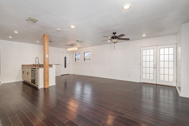 unfurnished living room featuring plenty of natural light and dark wood-type flooring