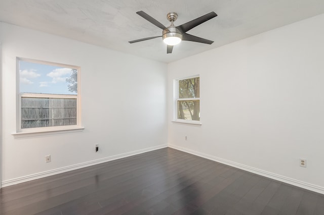 empty room featuring dark wood-type flooring and ceiling fan