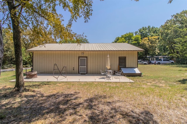 back of property featuring a patio and a lawn