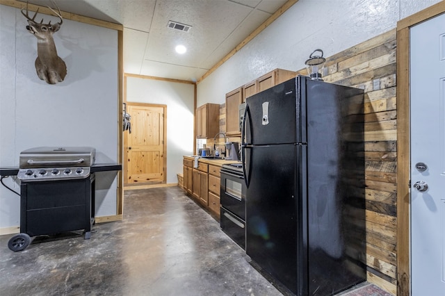 kitchen with black fridge, range with electric cooktop, and sink