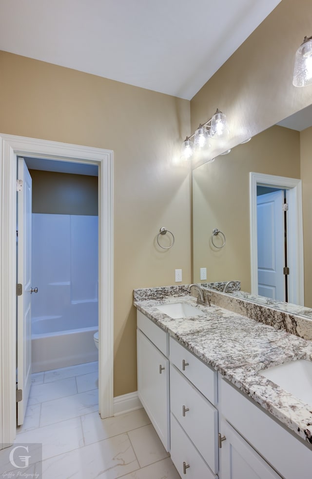 bathroom featuring dual vanity, toilet, and tile patterned floors