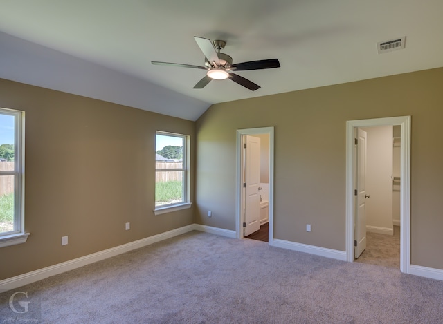 unfurnished bedroom with connected bathroom, ceiling fan, lofted ceiling, and light carpet