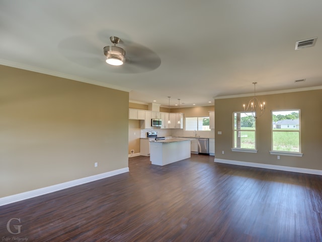 unfurnished living room with ceiling fan with notable chandelier, ornamental molding, and dark hardwood / wood-style floors