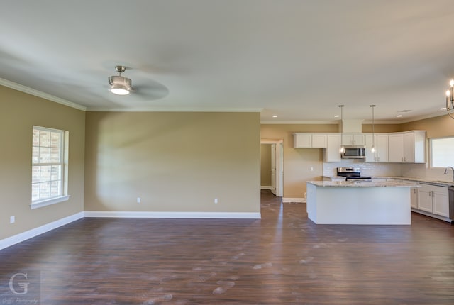 kitchen with dark hardwood / wood-style floors, appliances with stainless steel finishes, white cabinets, tasteful backsplash, and decorative light fixtures