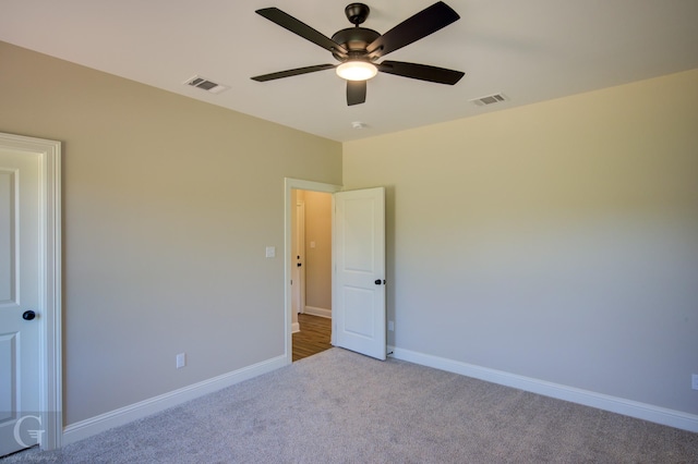 spare room featuring light carpet and ceiling fan