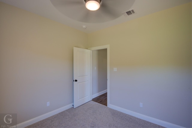 carpeted spare room with ceiling fan