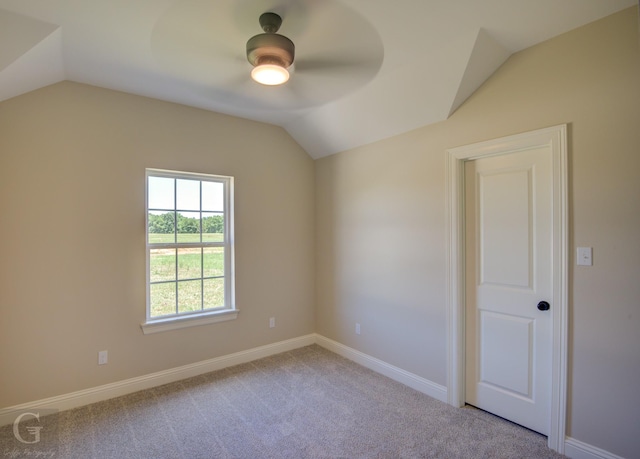 carpeted empty room featuring vaulted ceiling and ceiling fan