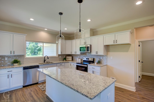 kitchen with sink, a center island, appliances with stainless steel finishes, light stone countertops, and white cabinets