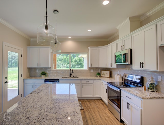 kitchen with sink, crown molding, appliances with stainless steel finishes, white cabinets, and decorative light fixtures