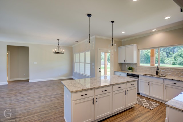 kitchen featuring a kitchen island, pendant lighting, sink, white cabinets, and stainless steel dishwasher