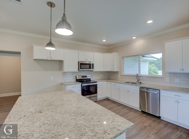 kitchen with decorative backsplash, light hardwood / wood-style flooring, stainless steel appliances, and decorative light fixtures