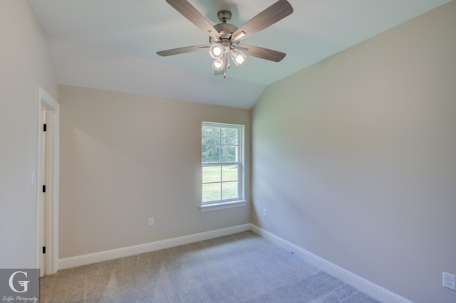 empty room featuring ceiling fan, carpet, and lofted ceiling