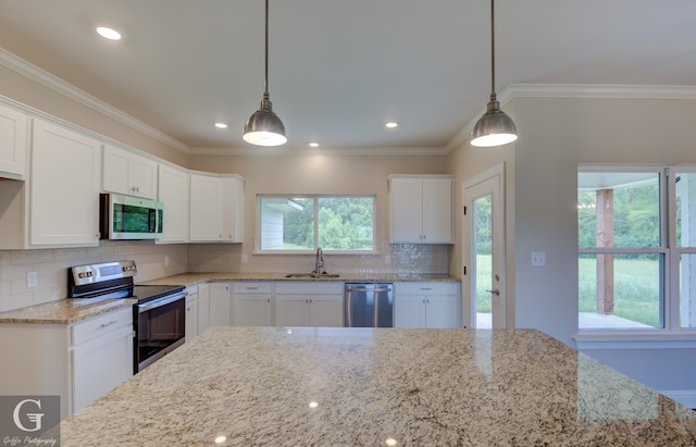 kitchen with appliances with stainless steel finishes, tasteful backsplash, plenty of natural light, and white cabinets