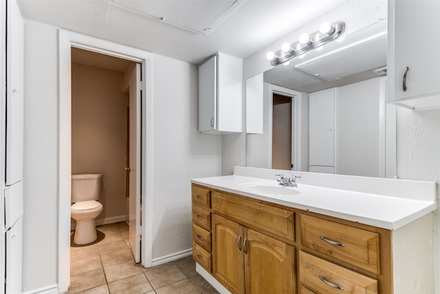 bathroom with vanity, toilet, and tile patterned flooring