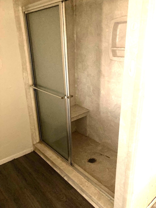 bathroom with hardwood / wood-style flooring and an enclosed shower