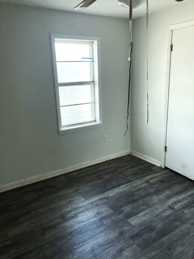 spare room with ceiling fan, dark wood-type flooring, and plenty of natural light