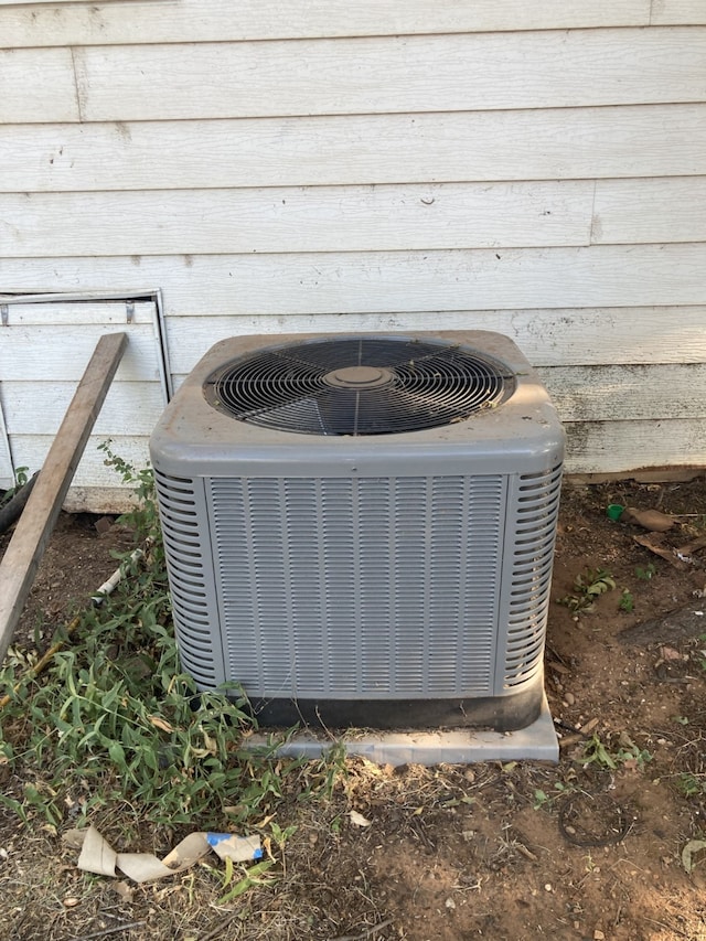 exterior details featuring central AC and wood walls