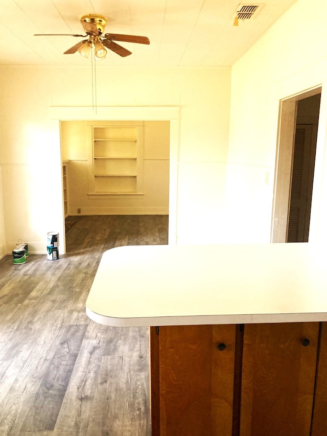 interior space with ceiling fan, built in features, and hardwood / wood-style flooring