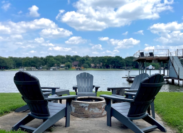 view of patio with a boat dock, a water view, and an outdoor fire pit