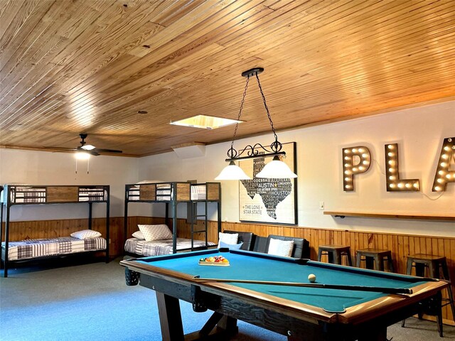 game room featuring ceiling fan, wood ceiling, wood walls, and carpet