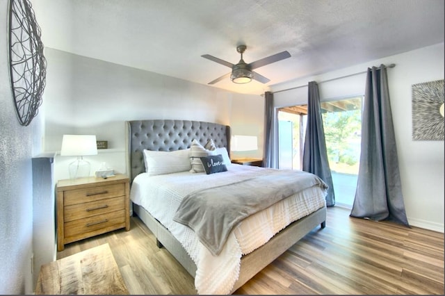 bedroom featuring access to outside, hardwood / wood-style floors, and ceiling fan