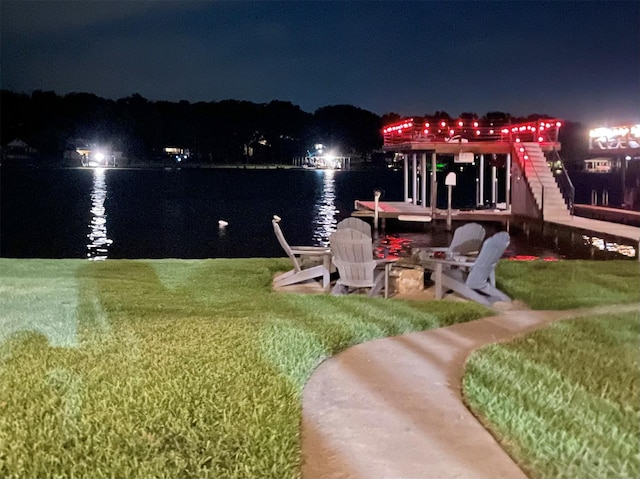 yard at twilight featuring a water view