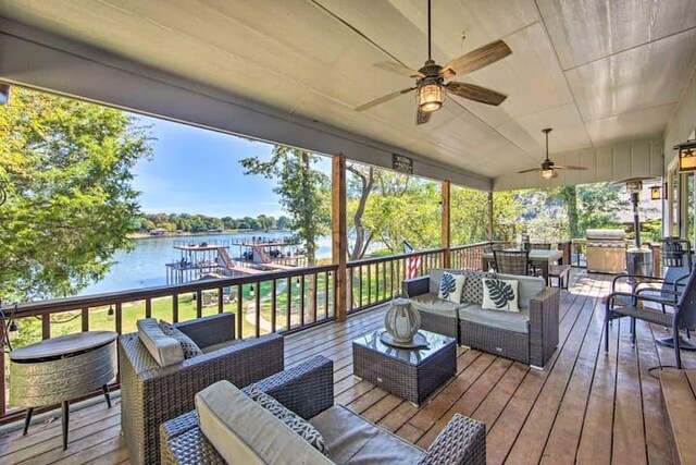 wooden terrace featuring a water view, an outdoor living space, and ceiling fan